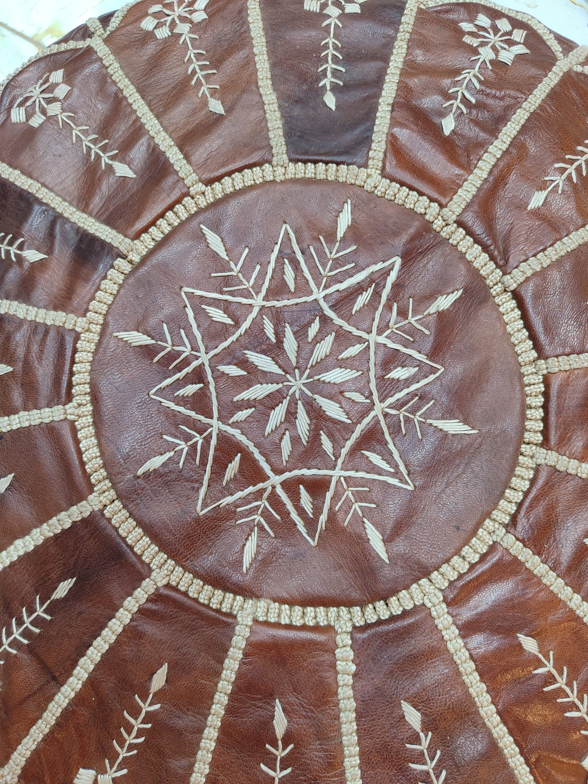 Handmade burgundy-brown Moroccan leather pouf — side view